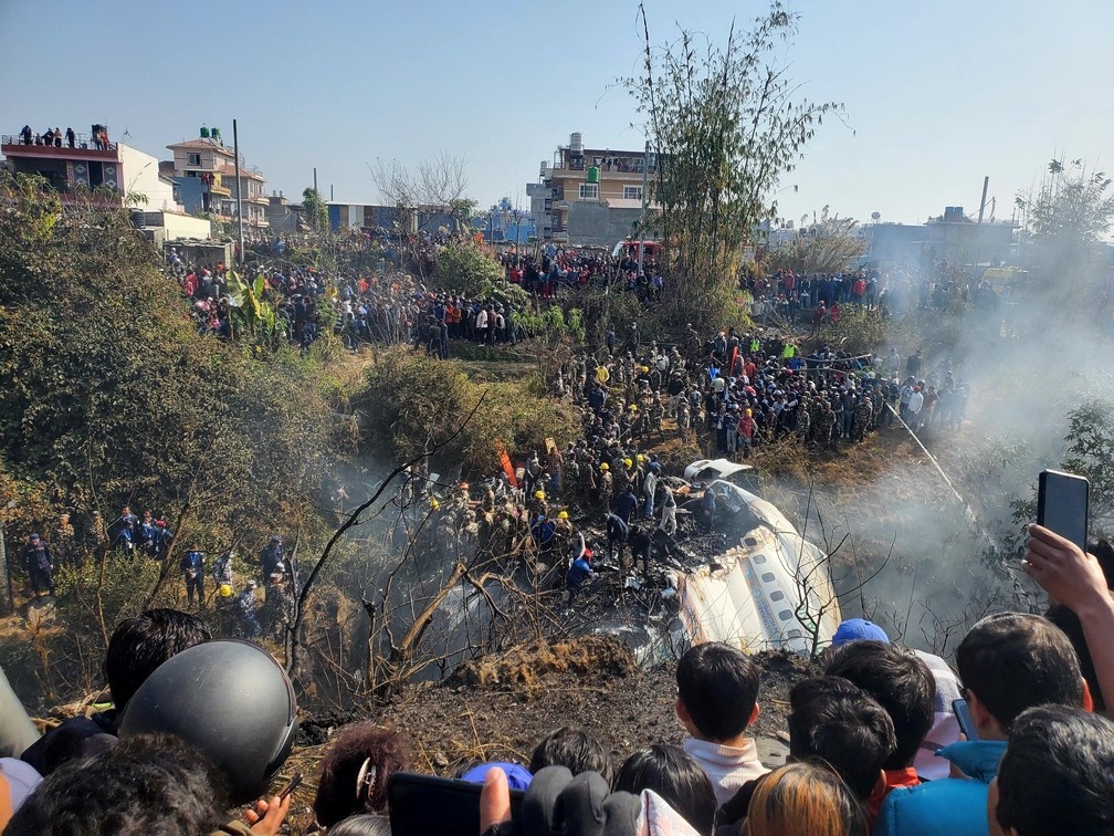 Pessoas reunidas após queda de avião no Nepal